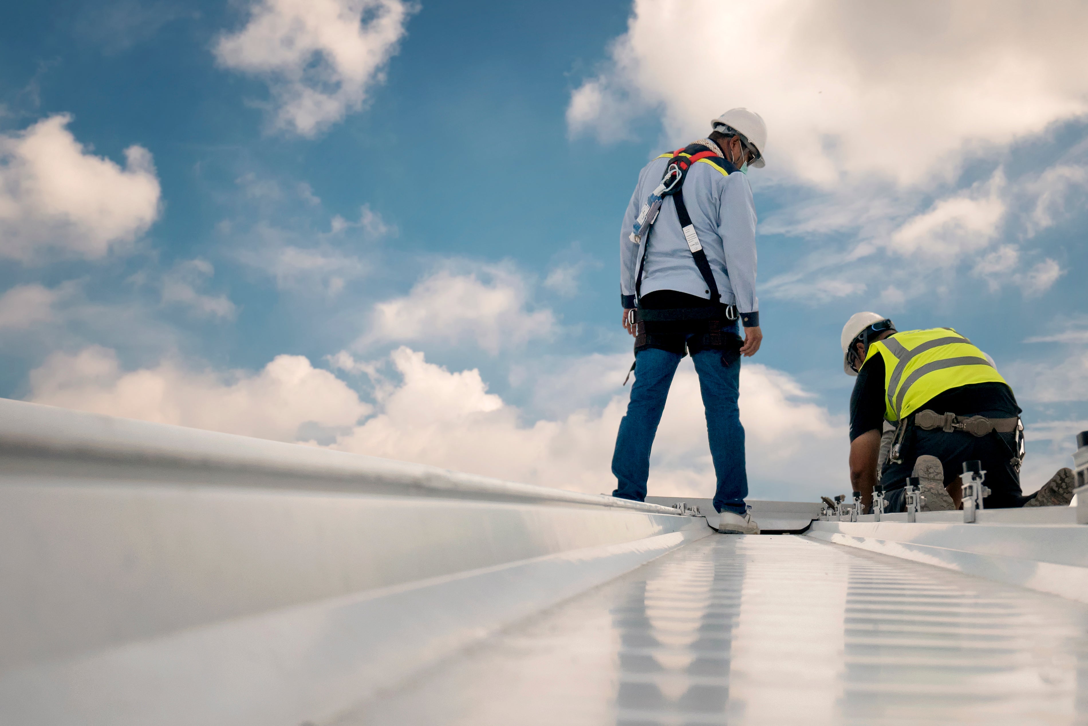 men on roof with hard hats and hi vis
